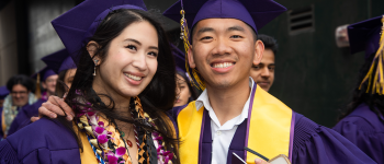 Two graduates pose for a photo