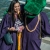Female Graduate in her regalia taking posing with the gator mascot wearing a regalia